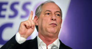 Foto de Ciro Gomes com boca aberta e dedo indicador apontado para cima.