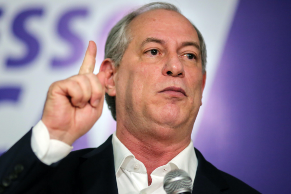 Foto de Ciro Gomes com boca aberta e dedo indicador apontado para cima.