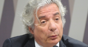 MP e TCU entram na Justiça para que Adriano Pires não assuma a presidência da Petrobras. Foto do rosto de Adriano Pires, com pelo branca, cabelo branco e e falando em um microfone de mesa.