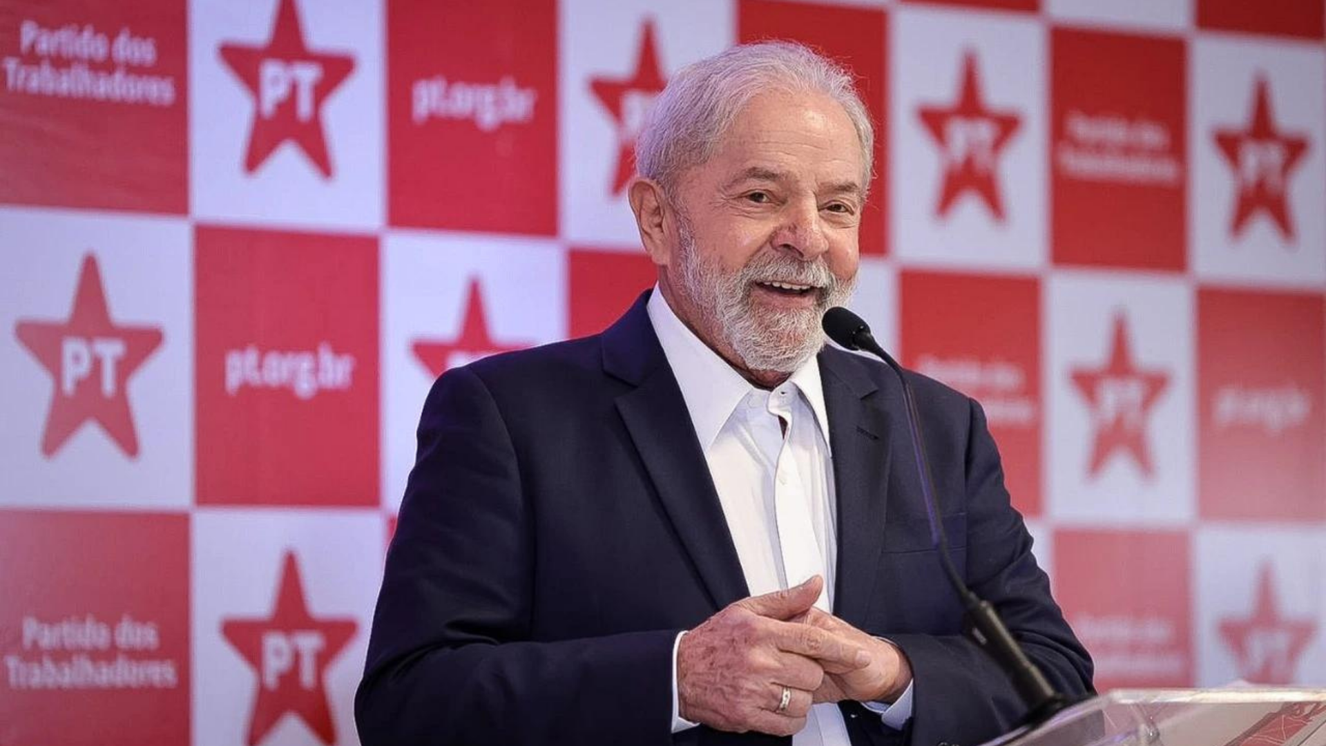 Foto de Lula sorrindo durante uma coletiva de imprensa.