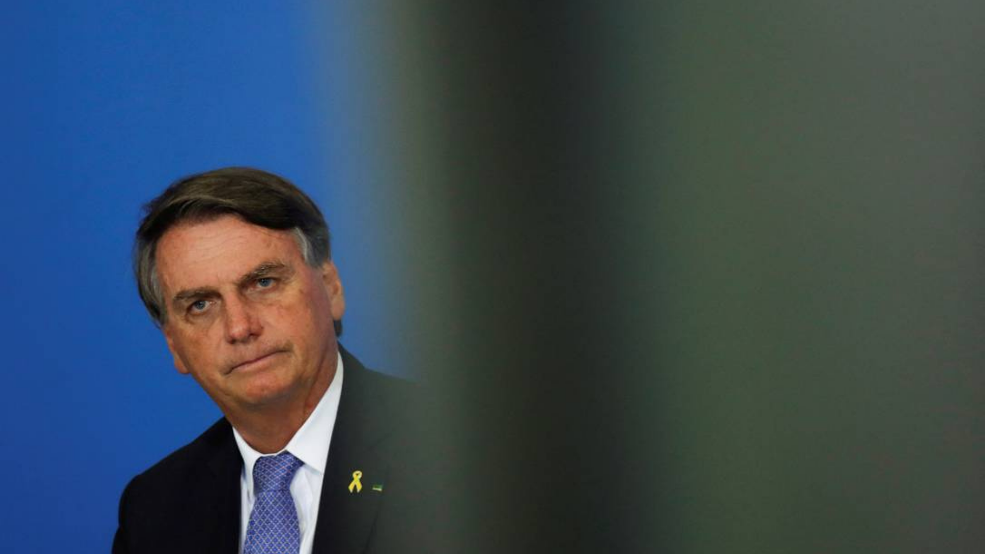 Foto de Bolsonaro com expressão de preocupação e passando sensação de pequenez.