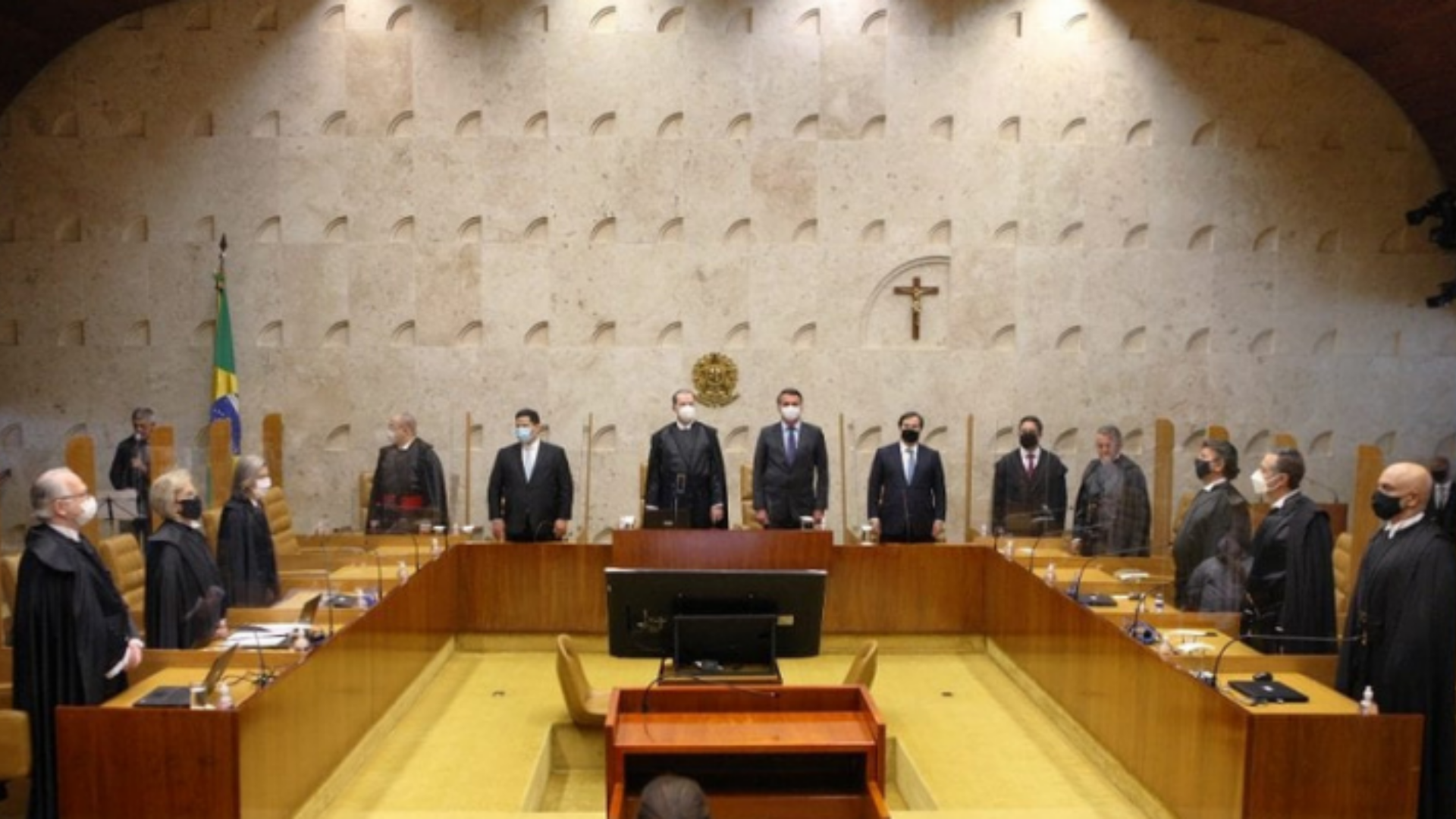 Foto do plenário do STF com todos os ministros em pé em frente às suas respectivas cadeiras.