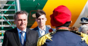 Foto de Bolsonaro com Jair Renan em Uberaba. Eles estão em um local aberto e usam trajes formais.