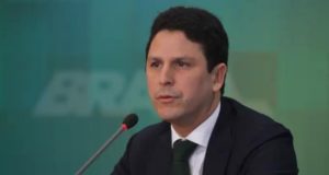 Foto de Bruno Araújo usando terno preto e falando ao microfone.