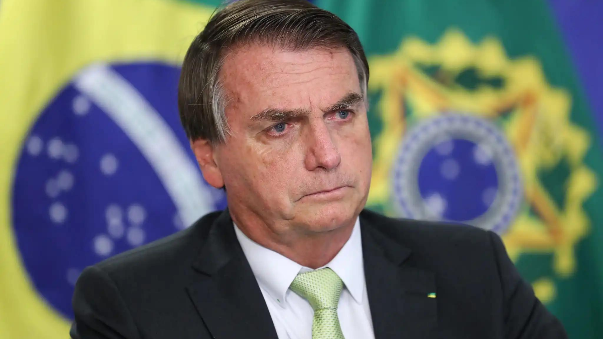 Foto de Bolsonaro com expressão séria e deprimido.