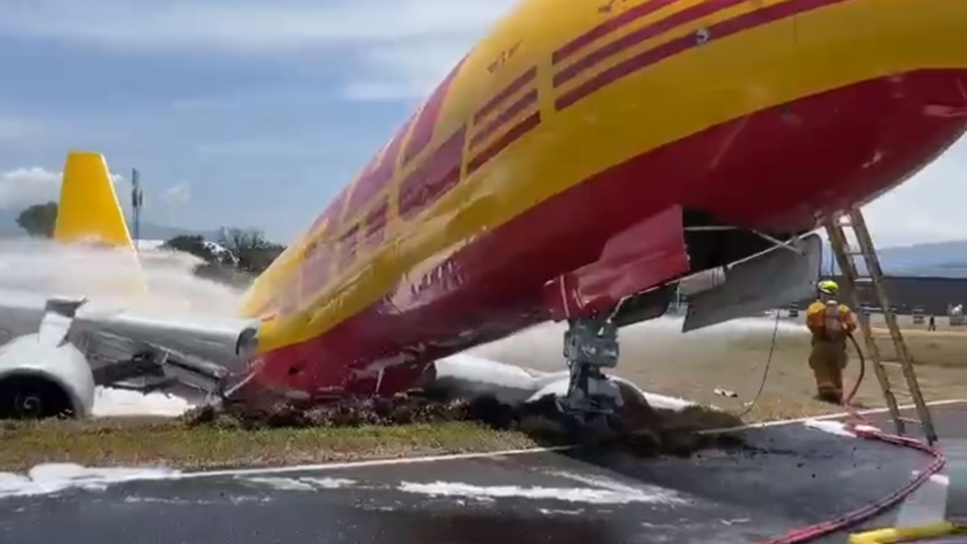 Avião cargueiro roda na pista e fica com fuselagem destruída. Foto do avião, nas cores amarela e vermelha, com a estrutura quebrada.