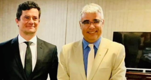 Senador Girão bancou viagem de Moro à Alemanha. Foto de Moro, com terno preto e sorrindo, ao lado de Girão, com terno branco, óculos de grau e sorrindo.