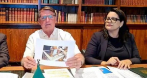 Foto de Bolsonaro segurando uma foto de uma urna durante a live semanal na quinta-feira (14).