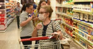 Foto de uma mulher dentro de um supermercado fazendo compras.