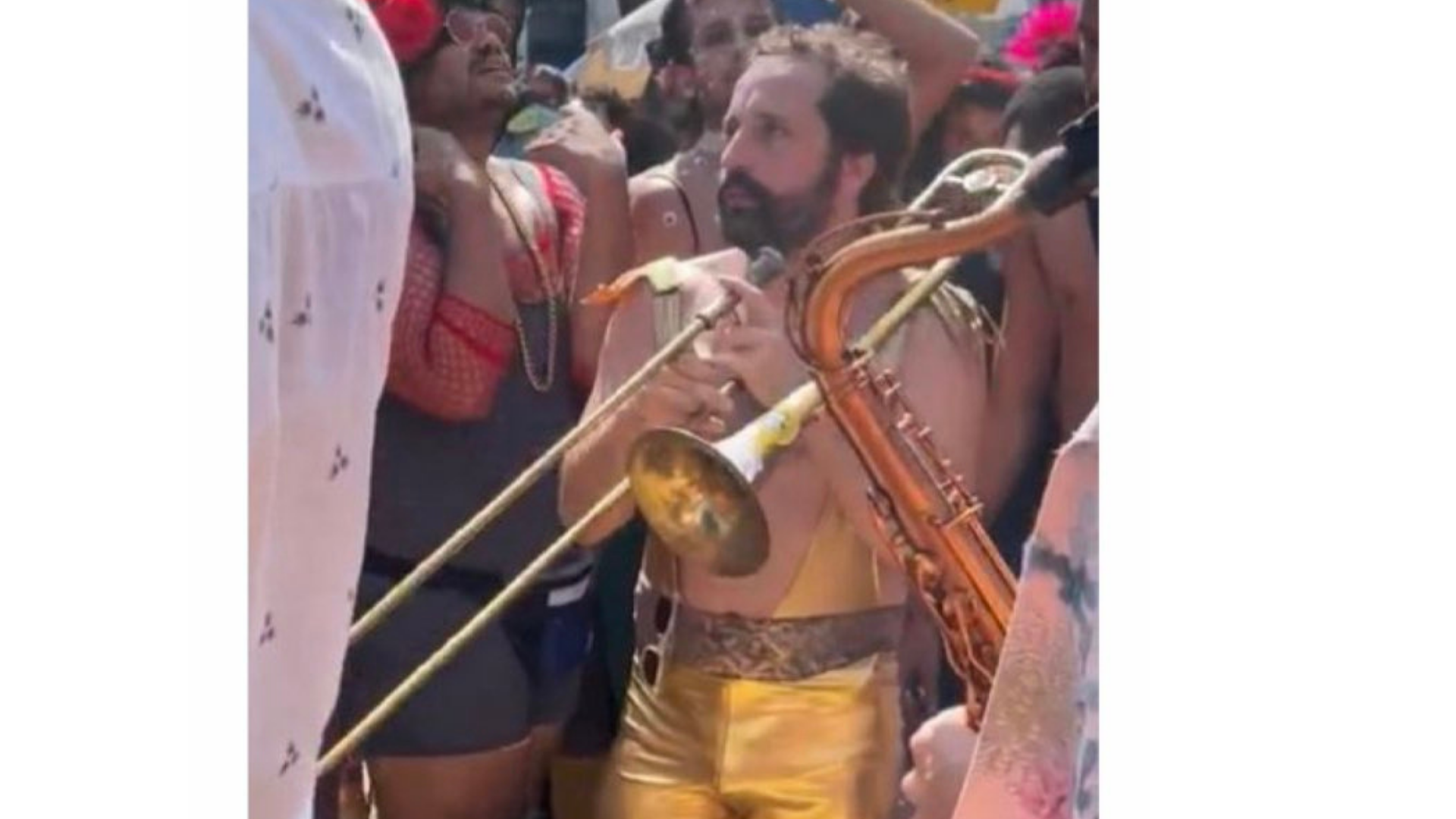 Gregorio Duvivier aparece com pele branca, barba e cabelos pretos, calça na cor dourada e sem camisa curtindo o carnaval do Rio.