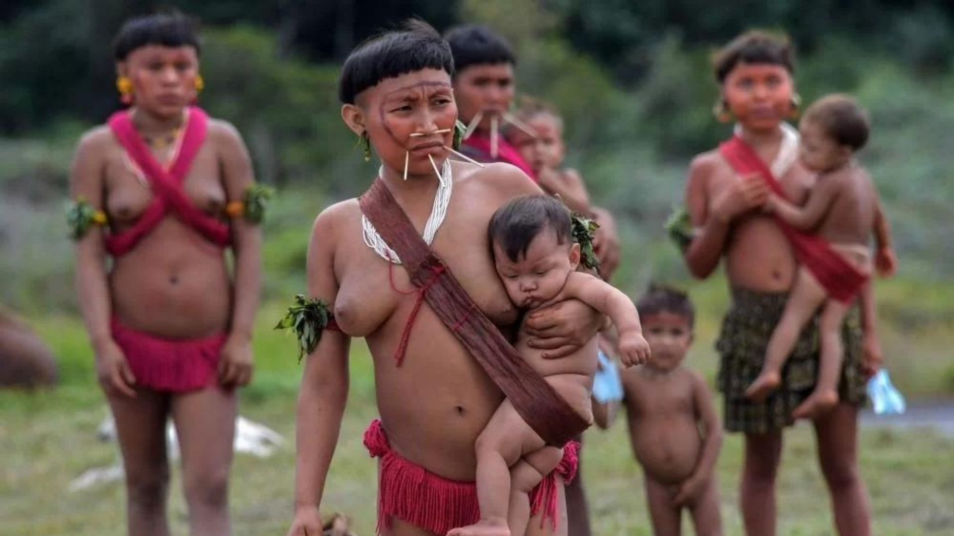 Foto de yanomamis com trajes tradicionais em um lugar ao ar livre. Eles são ameaçados por garimpeiros.