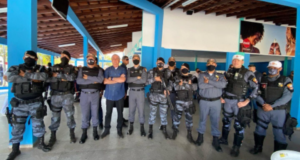 Foto de Bolsonao ao lado de policiais militares sorrindo.