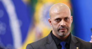 PF vai ter que tomar depoimento de Daniel Silveira em até 15 dias, ordena Moraes. Foto de Daniel Silveira com expressão séria, cabelo calvo e terno azul.