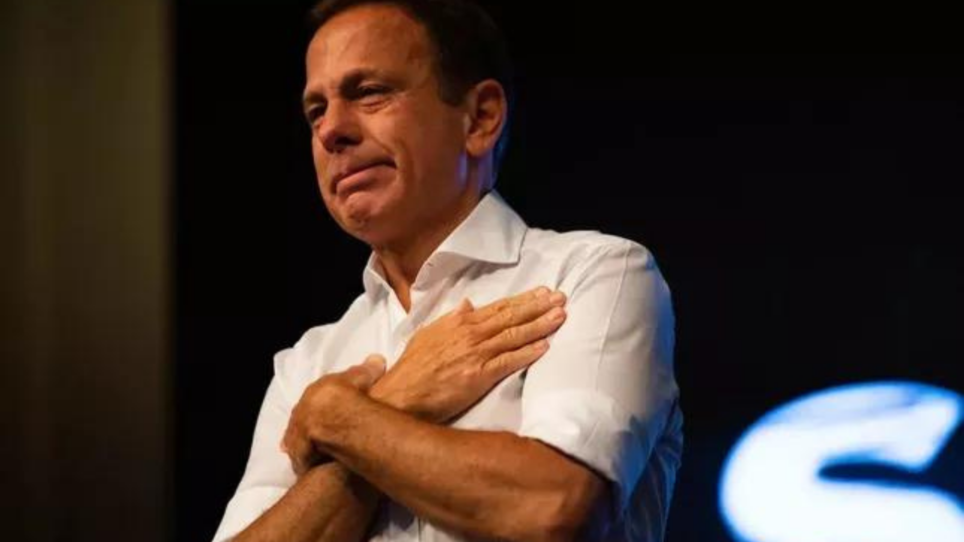 PT vai ao Ministério Público contra João Doria. Foto de João Doria com camisa branca e abraçando a si mesmo.