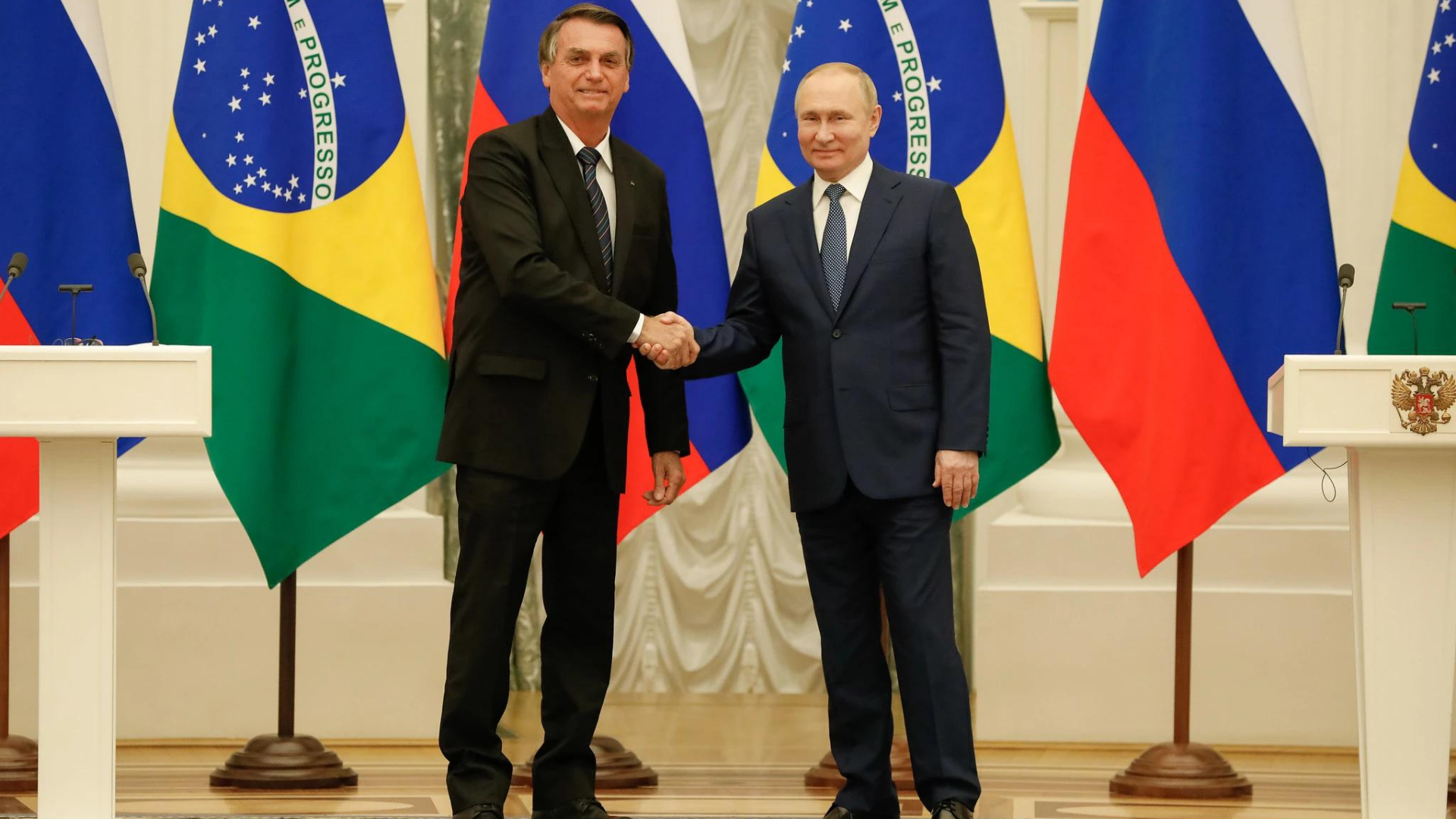Foto de Jair Bolsonaro em um aperto de mãos com o presidente da Rússia, Vladimir Putin.
