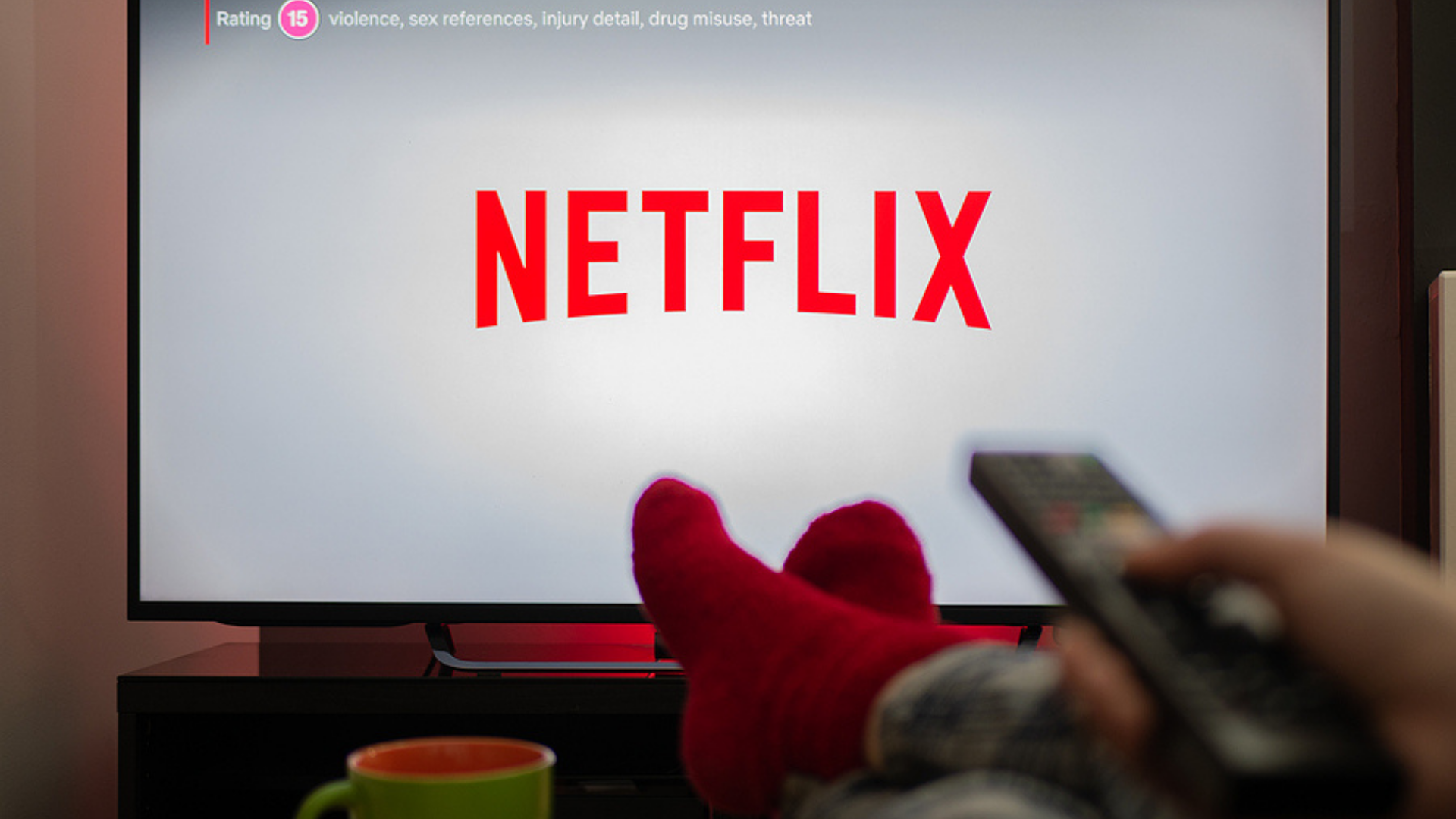 Imagem de uma pessoa deitada com a TV na Netflix.