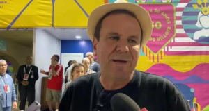 Foto de Eduardo Paes no carnaval do Rio falando ao microfone. ele usa um chapéu enquanto concede entrevista.