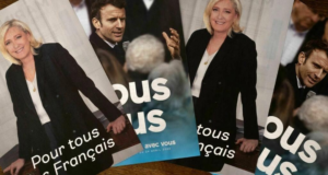 Foto de cartazes com imagens de Emmanuel Macron e Marine Le Pen.