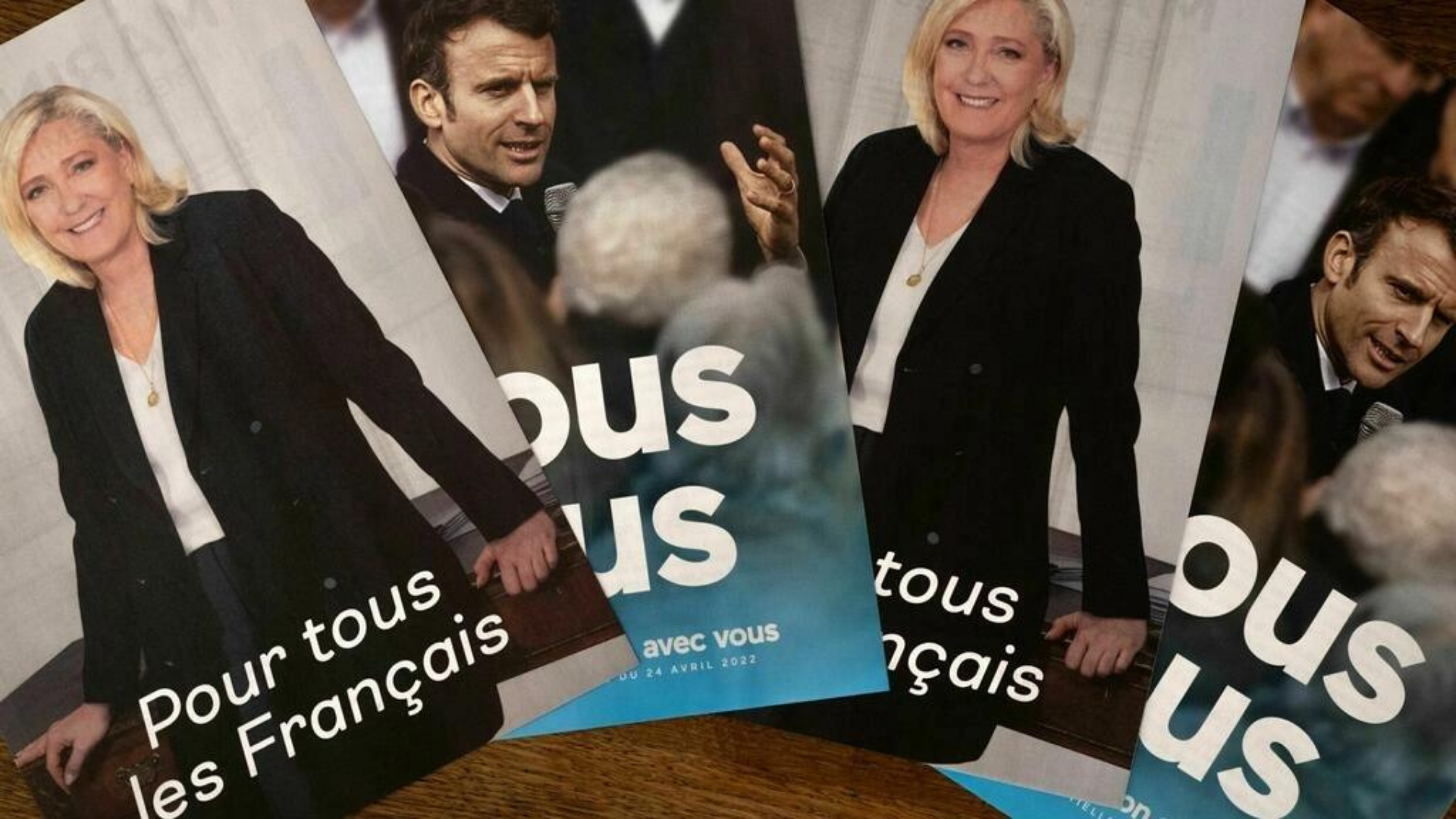 Foto de cartazes com imagens de Emmanuel Macron e Marine Le Pen.