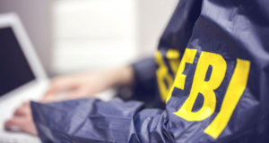 Foto de uma pessoa com uma farda do FBI escrita em amarelo.