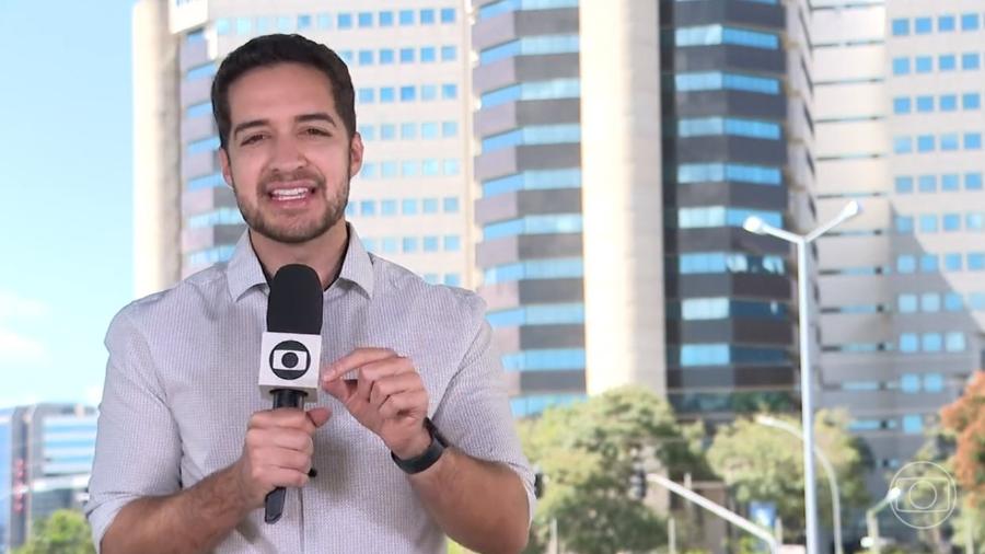 Gabriel Luiz trabalhando. Na imagem, ele segura o microfone da Globo e parece estar gravando uma reportagem.