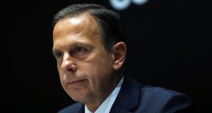 joão doria com fundo escuro e expressão séria