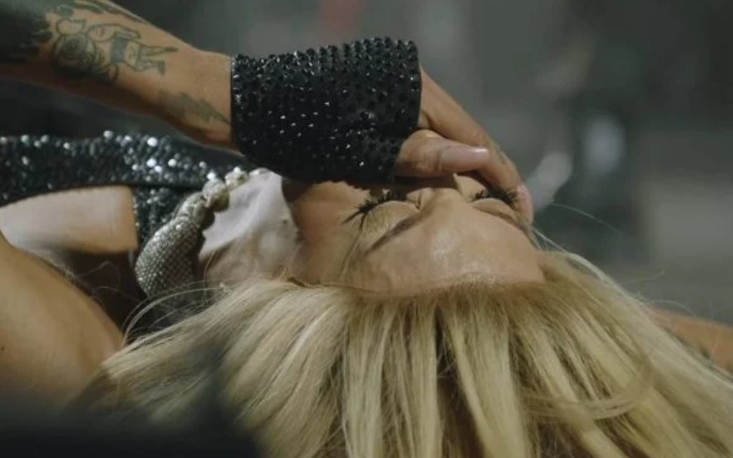 Pabllo Vittar deitada e chorando, com a mão no rosto.