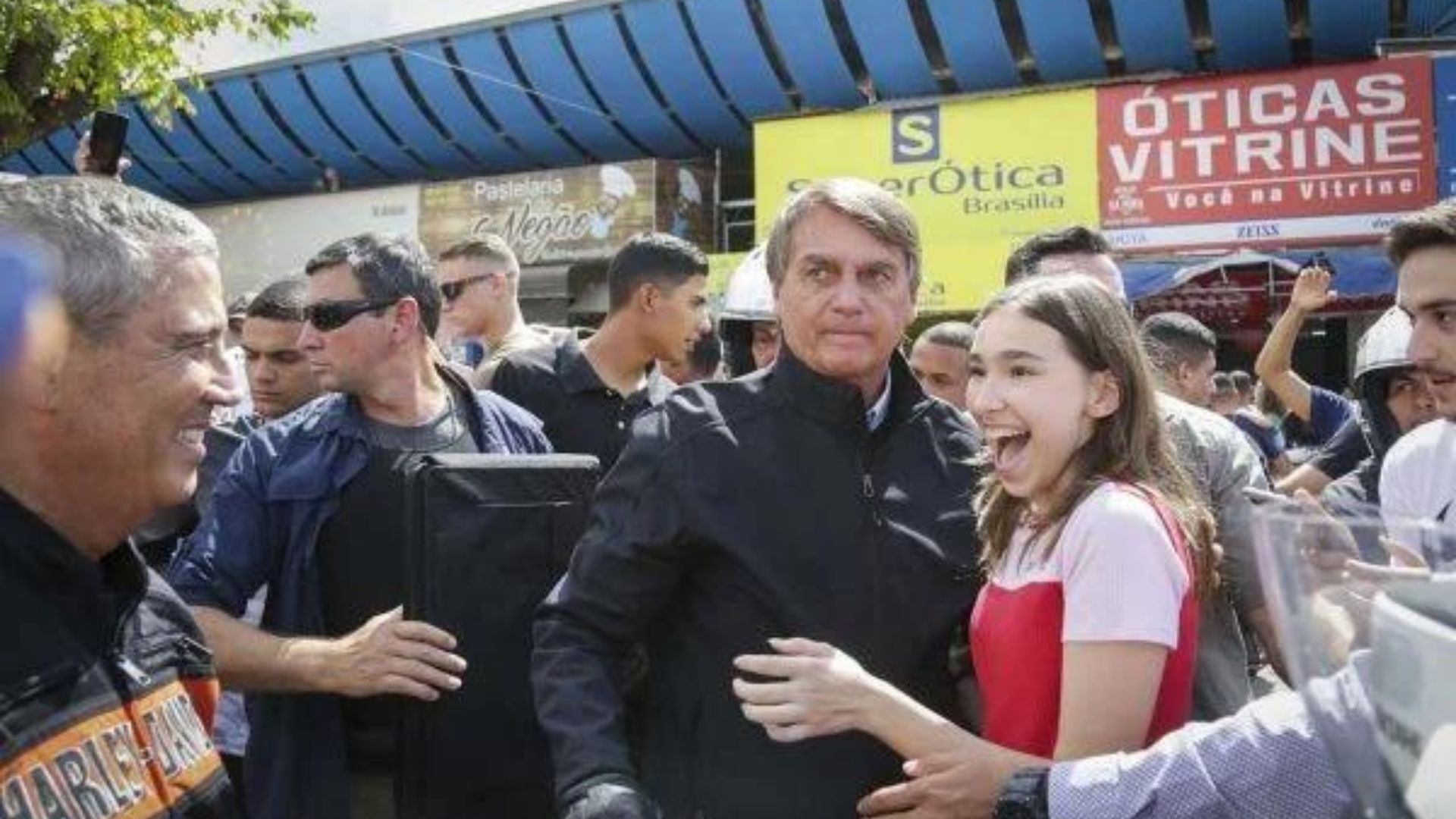 Foto de Bolsonaro com camisa preta ao lado de apoiadores.