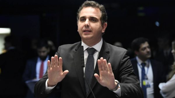 O presidente do Senado, Rodrigo Pacheco, com as duas mãos pedindo calma e expressão séria.