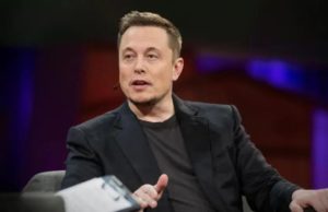 Foto de Elon Musk usando roupas pretas enquanto fala sentados em uma cadeira. Ele está em um TedTalk.