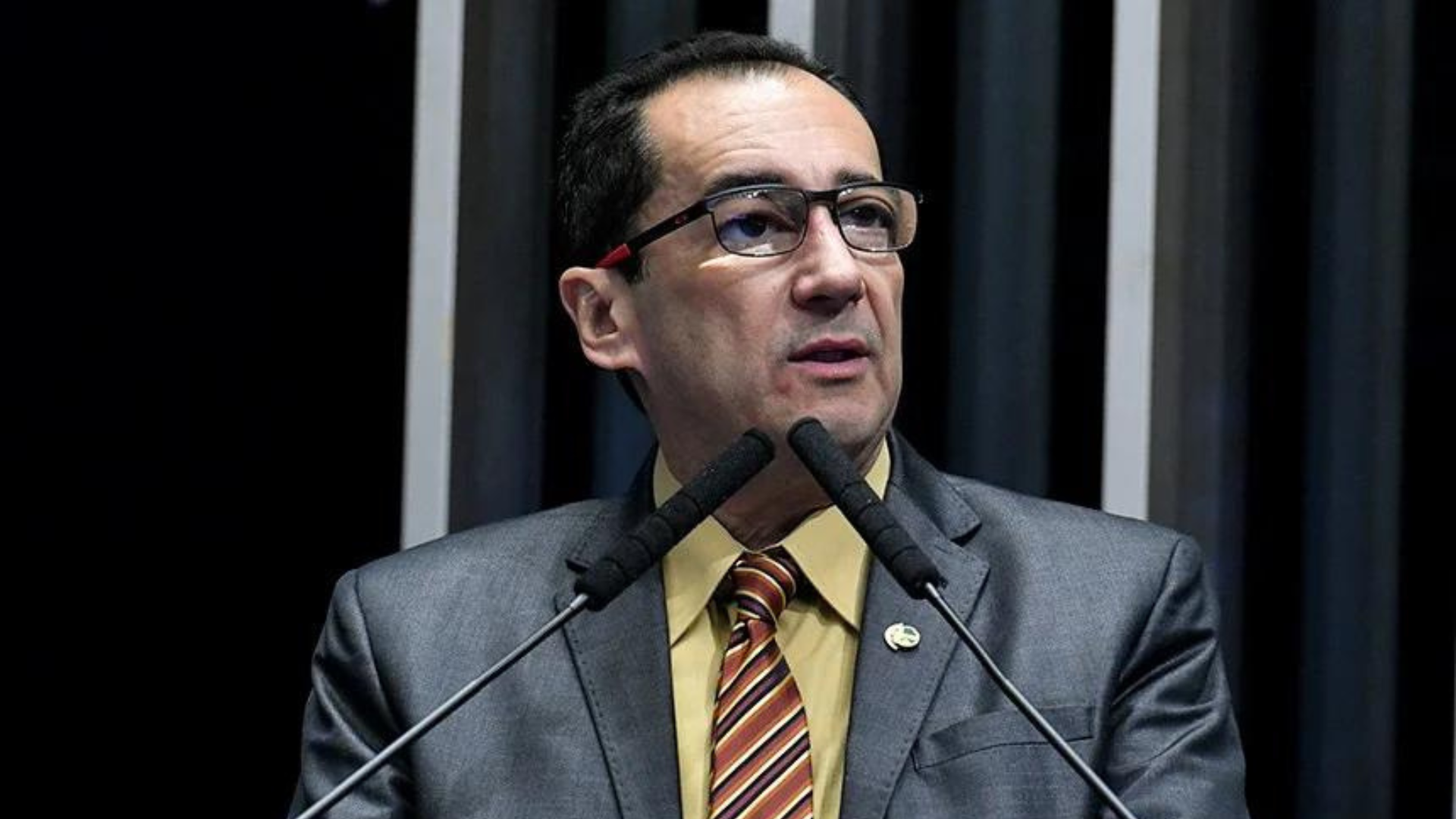 Foto de Kajuru com olhar sério e falando no palanque da Câmara.