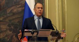 Sarguei Lavrov falando em um oúkpito. Ele veste terno preto e usa óculos.