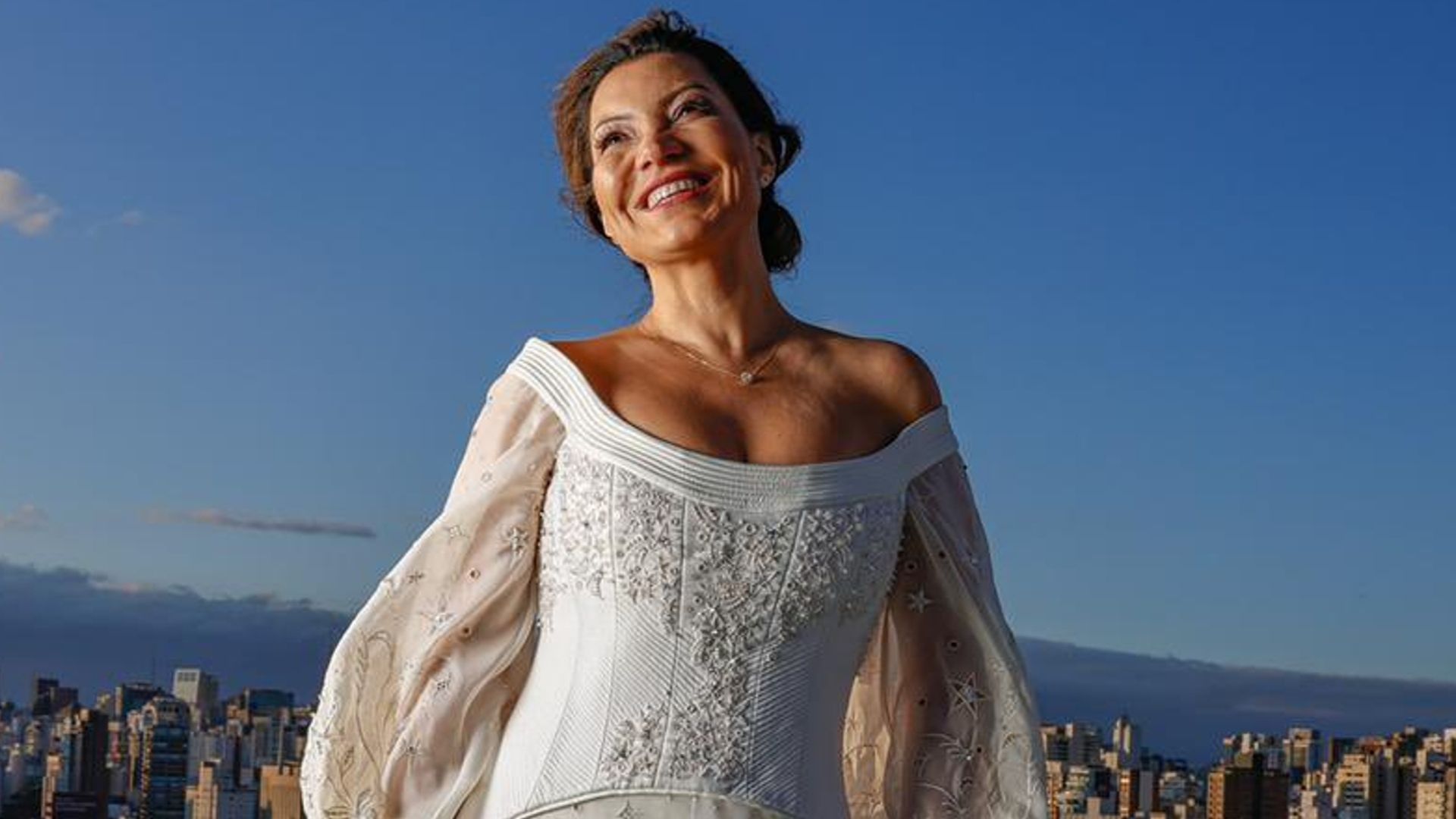 Foto de Janja sorrindo com o vestido de noiva feito por bordadeiras do Seridó potiguar.
