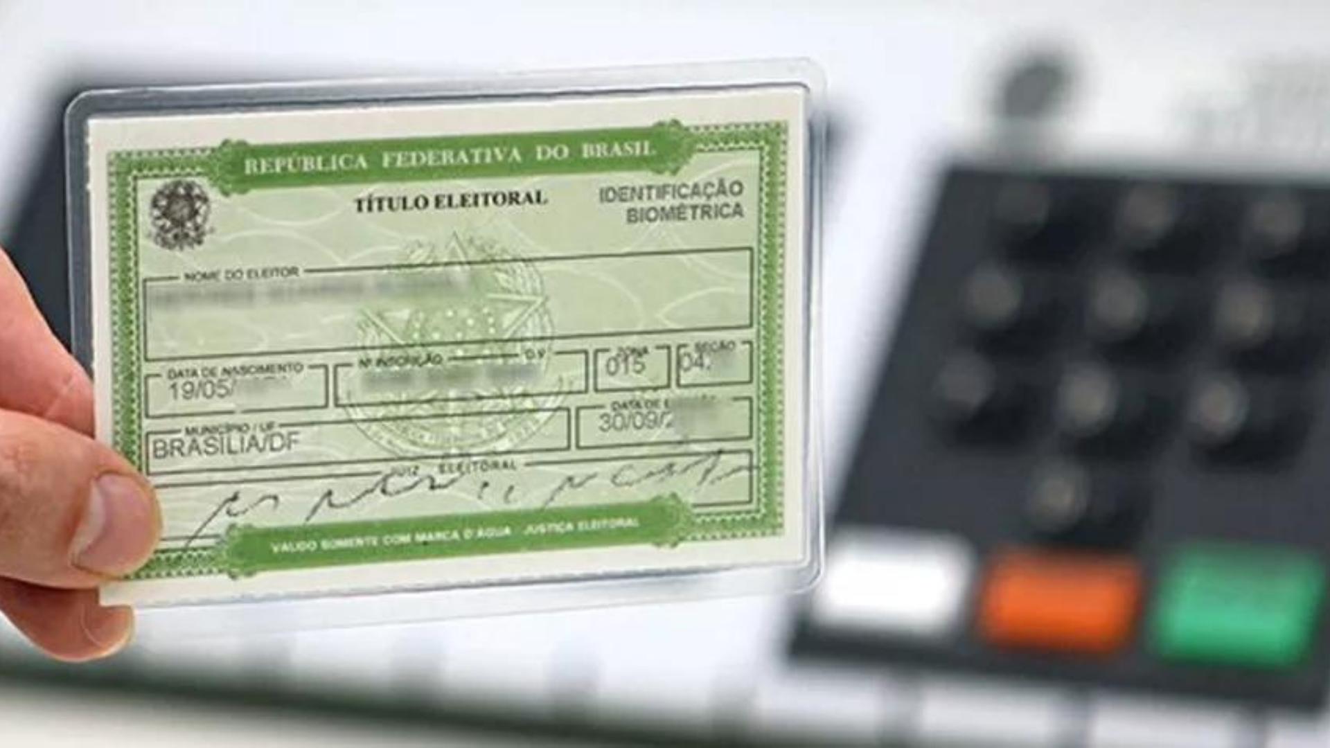 foto de uma urna eletronica junto com um titulo de eleitor.