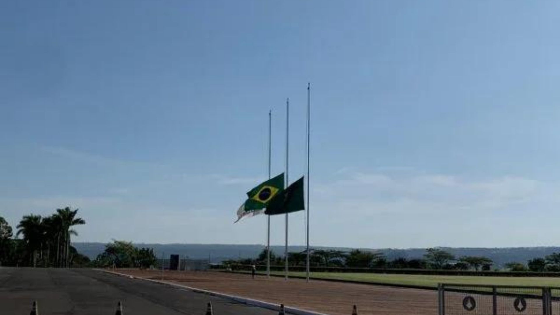 Foto das bandeiras da Presidência, do Mercosul e do Brasil a meio mastro.