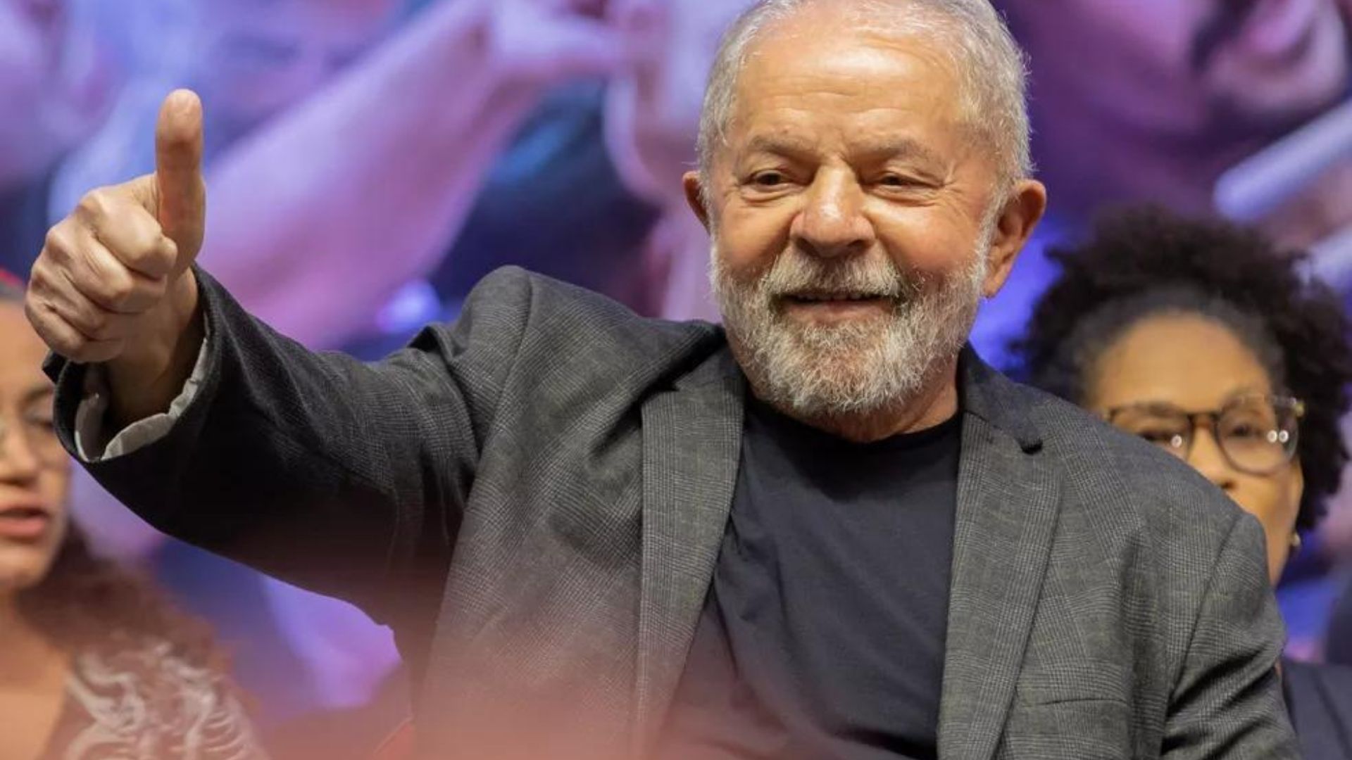 Foto de Lula fazendo sinal de legal e sorrindo para a foto.