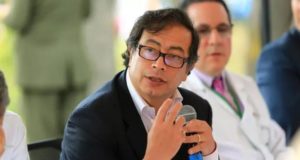 Foto de Gustavo Petro com óculos de grau, terno preto, pele branca.