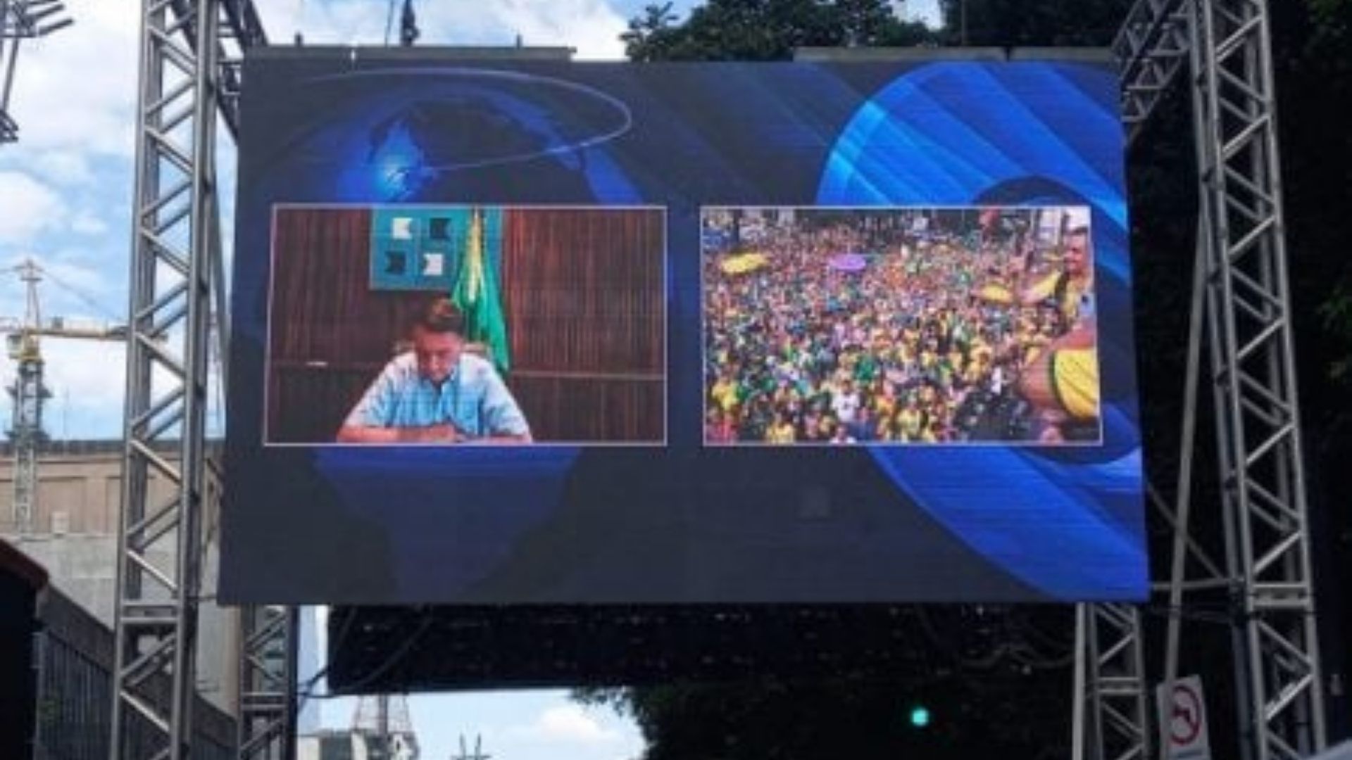 Foto de um telão na Avenida Paulista mostrando o presidente Bolsonaro em uma videochamada.