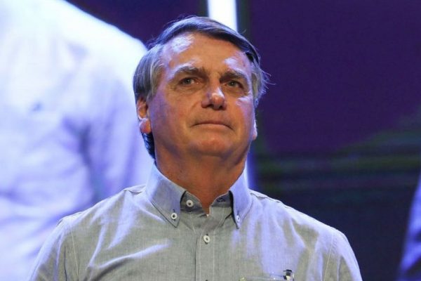 Jair Bolsonaro de camisa social azul clara, olhando pra frente sem sorrir