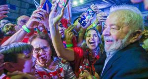 Lula sorrindo enquanto posa para fotos com populares