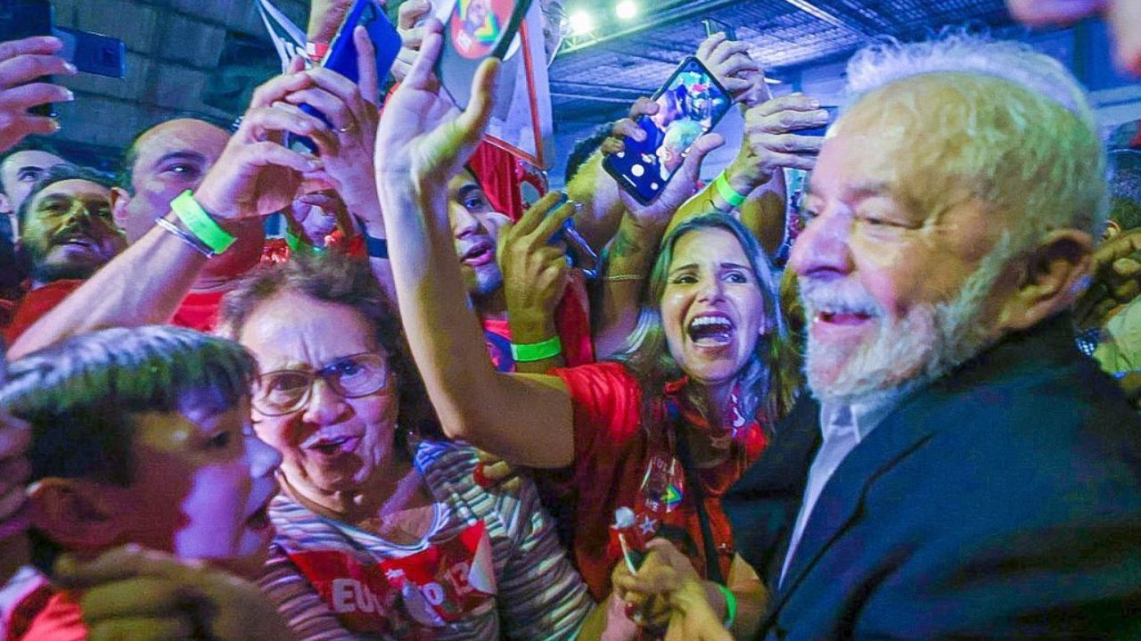 Lula sorrindo enquanto posa para fotos com populares