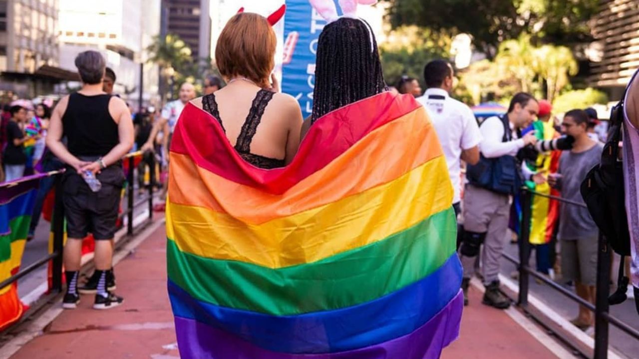 Duas mulheres de costas com a bandeira colorida