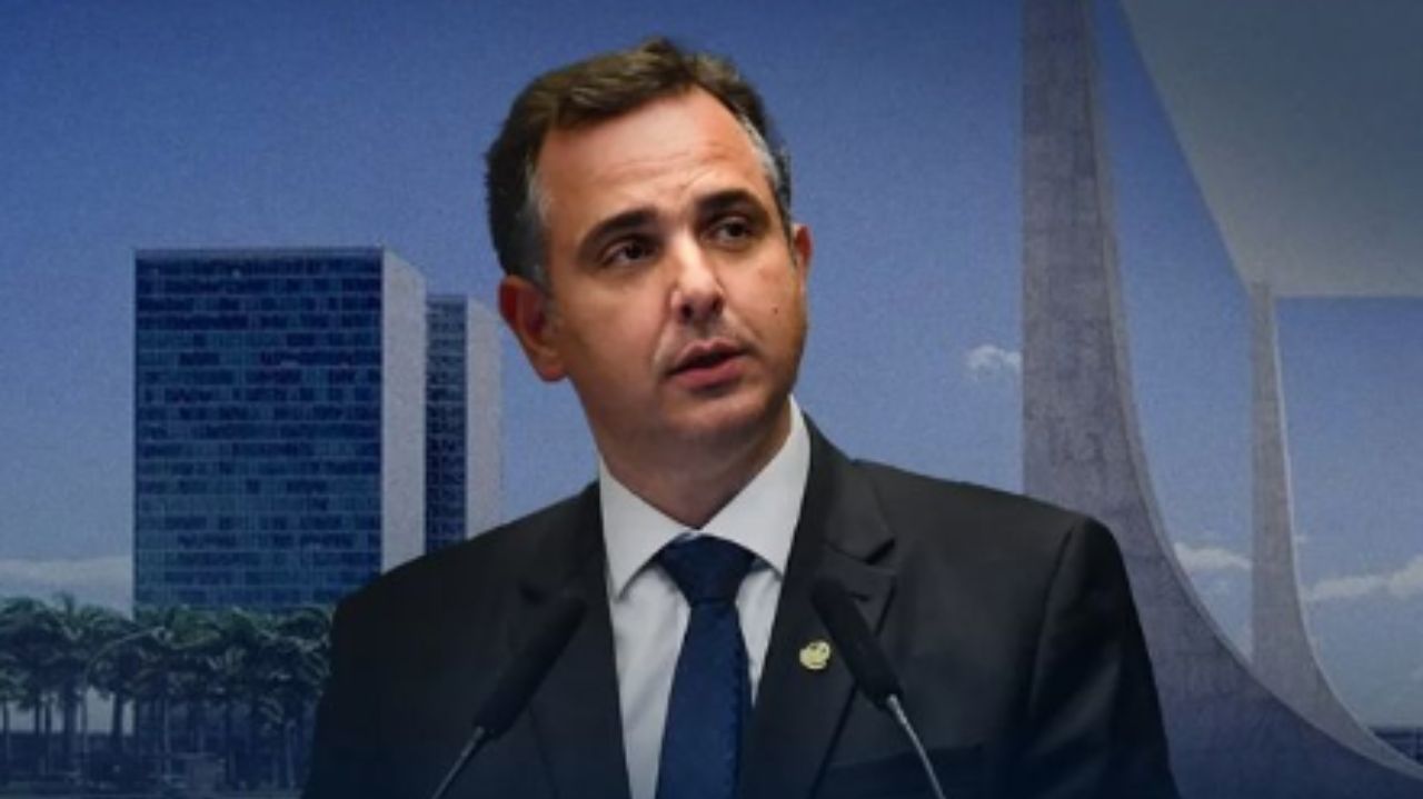Rodrigo Pacheco de terno preto, camisa branca e gravata azul, falando em microfone