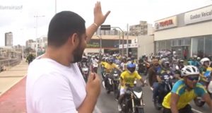 Daniel Ferreira de camiseta branca acenando para bolsonaristas em motos