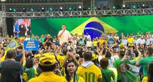 Jair Bolsonaro de camisa branca discursando perto de apoiadores
