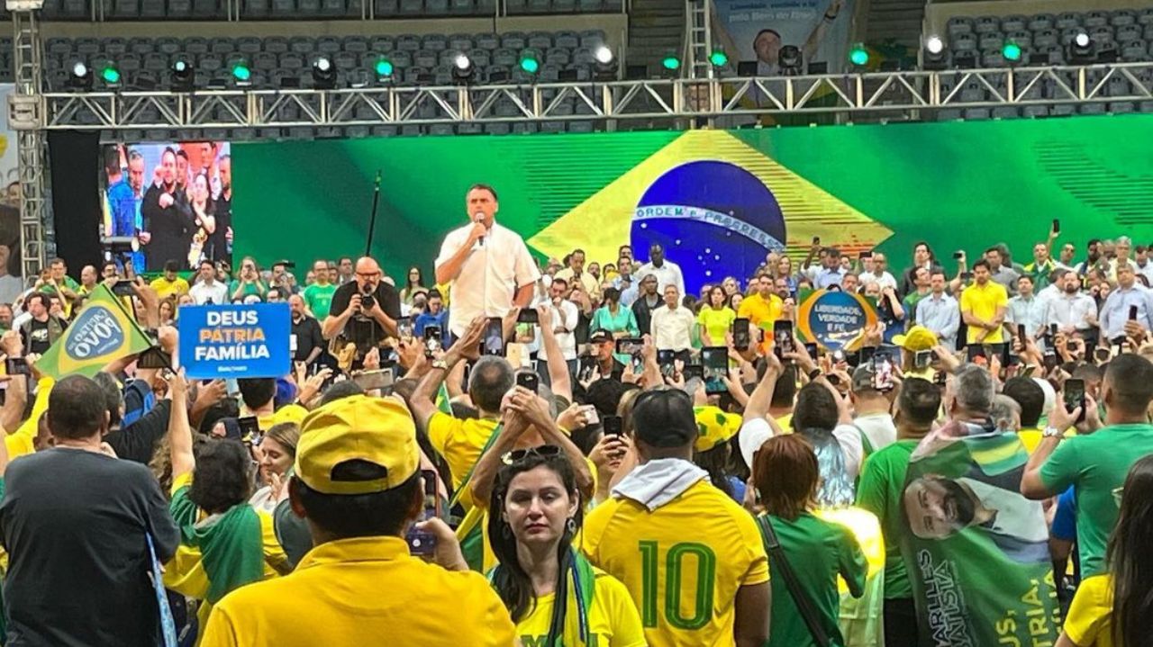 Jair Bolsonaro de camisa branca discursando perto de apoiadores
