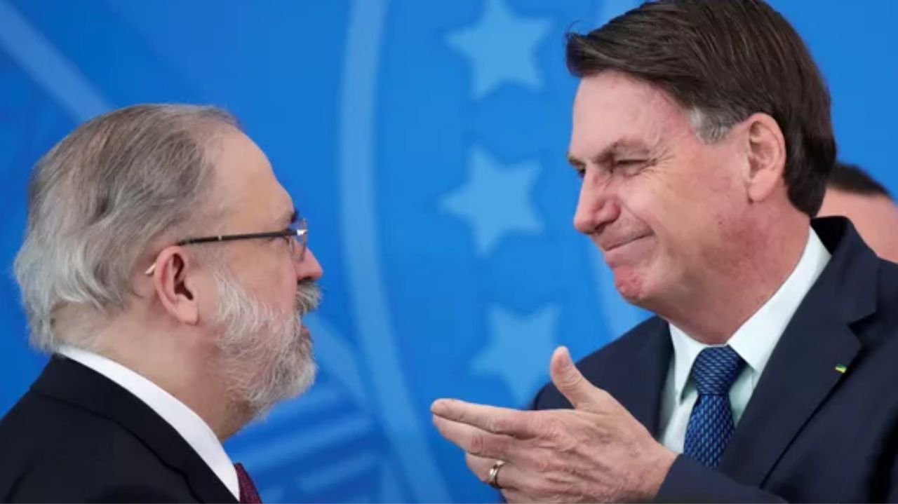 Augusto Aras e Jair Bolsonaro conversando, os dois de perfil