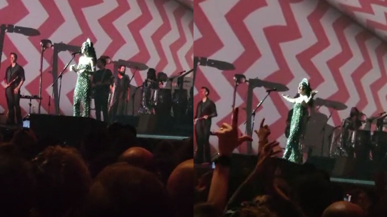 Marisa Monte falando perto de microfone em palco de show