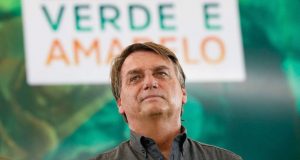 Jair Bolsonaro de camisa cinza com expressão confusa