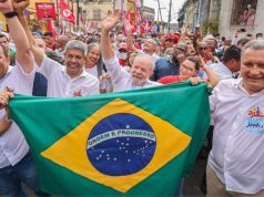 Lula sorridente com a bandeira do Brasil em caminhada em Salvador